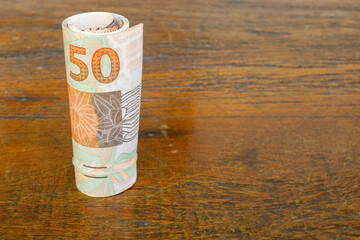 roll of brazilian money banknotes on the table