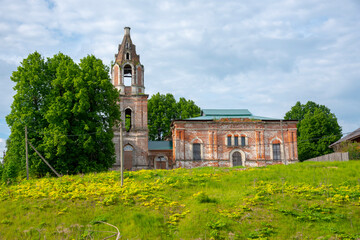 Fototapeta na wymiar An old brick dilapidated Church on a green hill .