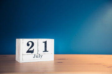 July 21 - white calendar blocks on wooden table against vintage blue background