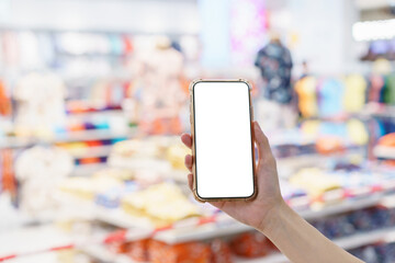 Mockup, hands holding blank white screen mobile phone in blurred department store, digital payment concept