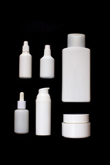 Simple Blank white Plastic Cosmetic Bottles Set.set of cosmetic products on a black background. Cosmetic package collection for cream, soups, foams, shampoo. Mock up white cosmetic bottles on black