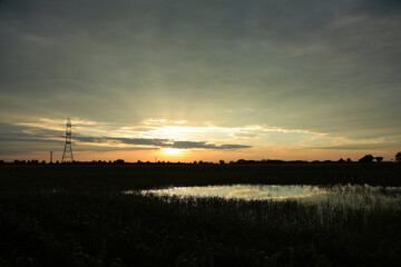 Zachód, wschód słońca nad polami, malownicze niebo, lustrzane odbicie. © Stanisław Błachowicz
