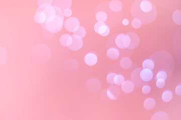 Abstract bokeh, defocused of water drops reflects light on pink gold background.