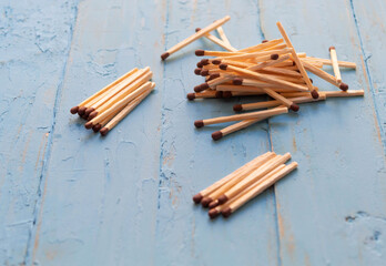 Matches, necessary in everyday life, lie small piles on a blue background