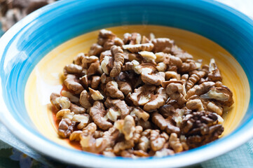 bright color plate with walnuts. Eco food. The shell of walnuts, clean of nuts