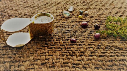 On a jute cloth, a gem loupe and different types of precious gemstones including star ruby, star...