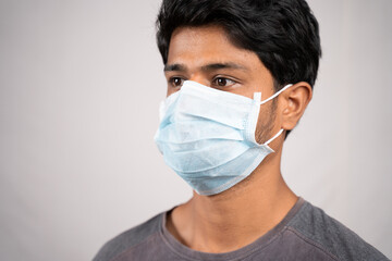 Young man properly covered nose and mouth with face mask - Awareness and safety concept to ware mask properly, to protect from coronavirus or covid-19 crisis on isolated background.