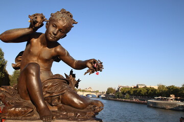 Fototapeta na wymiar estatua antigua en París con candados colgando de sus manos