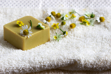 Obraz na płótnie Canvas Handmade soap with medicinal herbs, flowers and a towel.