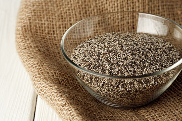 Glass bowl with chia seeds on wooden table
