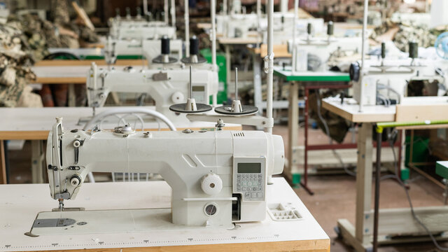 Interior of a workshop for sewing clothes and textiles. Without people. The workroom of seamstresses and dressmakers. Industrial scale.