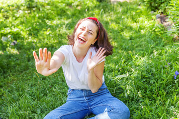 Happy girl smiling outdoor. Beautiful young brunete woman with brown hair resting on park or garden...