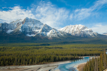 Snow capped peaks and the Athabasca River  in the Canadian Rockies, viewed from the Icefields Parkway, which extends from Banff to Jasper, Alberta, Canada.
