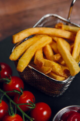 French fries and tomatoes on a table in a restaurant. Fast food, junk food