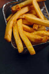 French fries in a basket on a table in a restaurant. Fast food, junk food