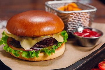 Burger with fries and ketchup on a table in a restaurant. Fast food, junk food