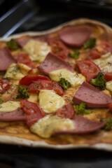 pizza with ham tomato cheese and broccoli