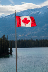 The Canadian maple leaf flag flying over Jasper Lake, Alberta, Canada.