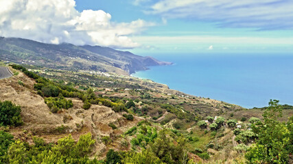 View over the green and wild east coast of La Palma, Canary Island near the small town La Galga / Puntallana and the Atlantic. The sky is blue with white clouds
