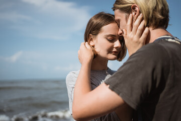 Young couple enjoy a trip together on the beach in the bright sunny day