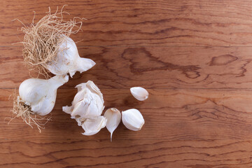 Untrimmed garlic on cutting board with space - 362971260