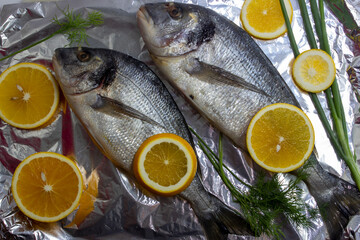 Two fresh dorada fish with lemon and dill on top