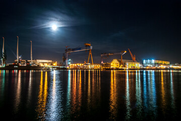 Container Harbor in Kiel Germany for freight transport and shipping of trade exports illuminated at night with bright moon