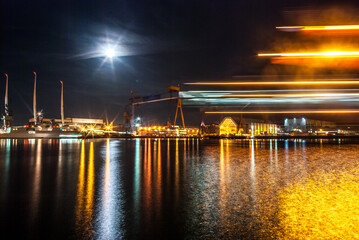 Container Harbor in Kiel Germany for freight transport and shipping of trade exports illuminated at night with bright moon and motion blur