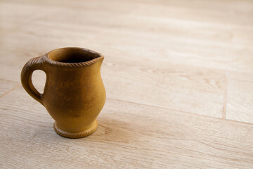 Small clay milkman handmade on a wooden background.