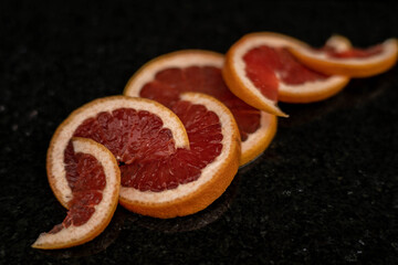 Grapefruits close up on black stone background