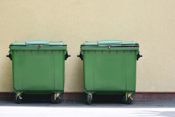 Garbage cans on the street near the wall