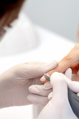 Manicure master uses an electric nail machine to remove nail polish hands in nail salon