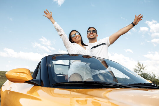 Cheerful Young Couple Going On A Long Drive In A Convertible Car. Freedom, Travel And Love Concept.