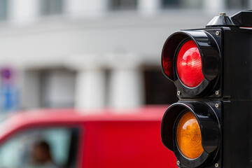 traffic control semaphore with red light on a defocused city background