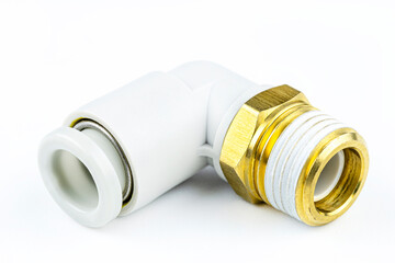 Macro shot of a white, pneumatic elbow fitting for a plastic tube with a 1/2 inch brass external...