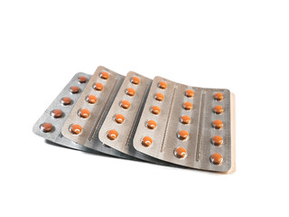 Several blisters with beige tablets in three rows isolated on a white background. Medications, treatment and health care. 