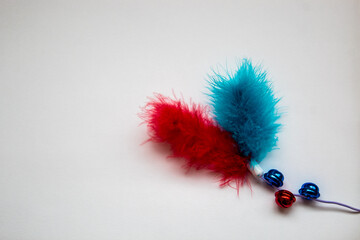 red and blue feather with bells for playing with a cat