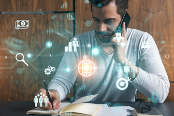 Handsome manager in casual talking phone and taking notes at office workplace try to discover new approaches to optimization of business process. Double exposure. Fintech concept.