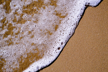 texture of sand and sea foam on the black sea beach, copy space