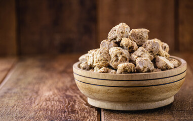 Granulated PINK SOY PROTEIN. Soy based protein on rustic wooden background.