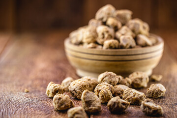 Granulated PINK SOY PROTEIN. Soy based protein on rustic wooden background.