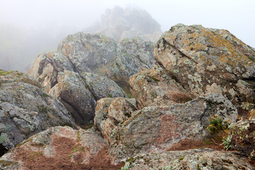 Fototapeta na wymiar Pile of huge stones of rocks in the autumn fog at sunrise