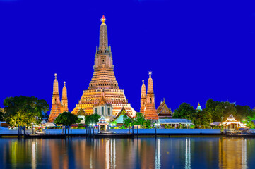 Naklejka premium View over the Wat Arun Temple with its refiections in the river, at the twilight, Bangkok, Thailand