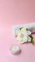 Fototapeta na wymiar Spa setting and Spa background composition with white gardenia flower on pink background. vertical photo