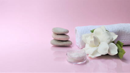 Fototapeta na wymiar Spa setting and Spa background composition with white gardenia flower on pink background. Banner