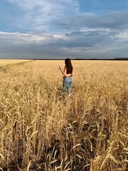 Young lucky girl in a wheat field. A person standing in a field of tall grass