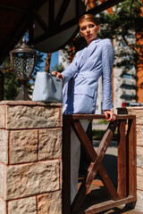 A business girl in a blue summer pantsuit is located next to the restaurant