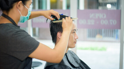 a young man is getting a haircut in a hair salon, Salon safety concept