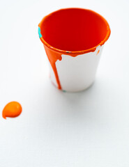 Paint pot filled with orange paint isolated on white background