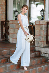 A girl in a light summer suit with a bag. Demonstration of clothing